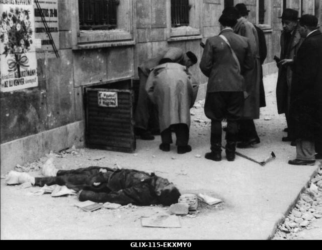 Szabadságharcosok láthatók itt, amint a szénpincén keresztül törnek be egy házba. A ház az AVO (Titkosrendőrség) erődítménye volt, és az előtérben...