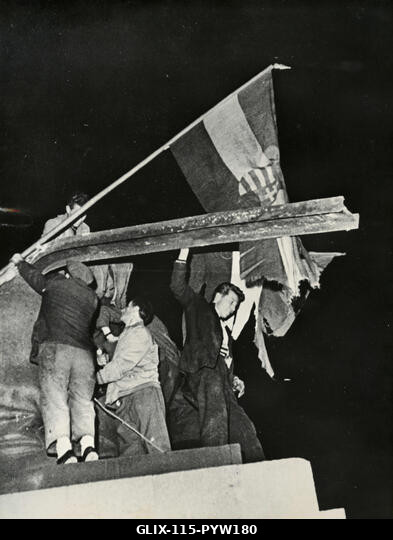 Magyar hazafiak tűzik ki a nemzeti zászlót a Sztálin-emlékmű fennmaradó részére, Budapest, Magyarország, 1956